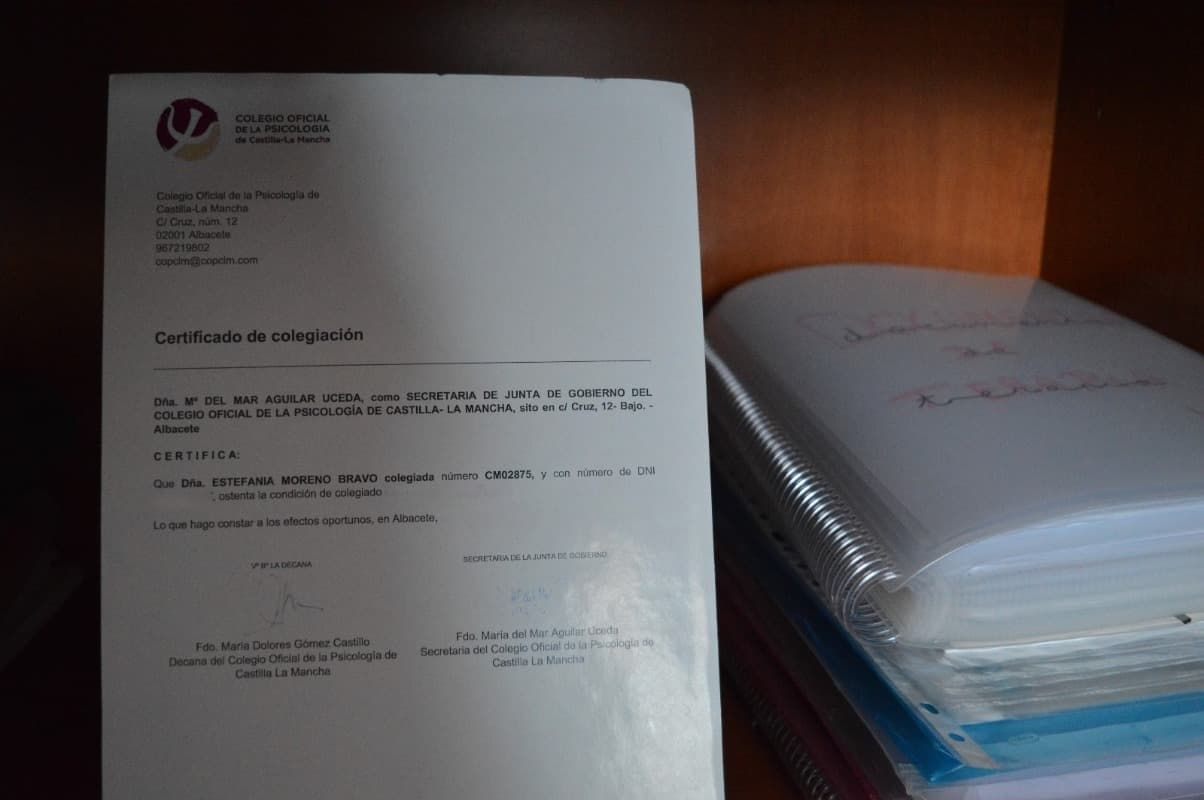 Hay una carta en un estante junto a una pila de papeles.