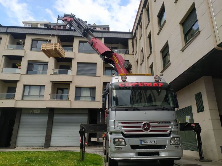Un camión Mercedes está estacionado frente a un edificio.