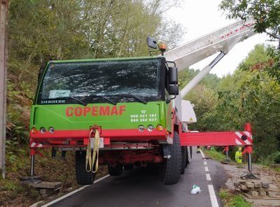 Un camión verde y rojo de Copemaf está estacionado al costado de la carretera.