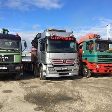 Tres camiones estacionados uno al lado del otro y uno de ellos decía copemap