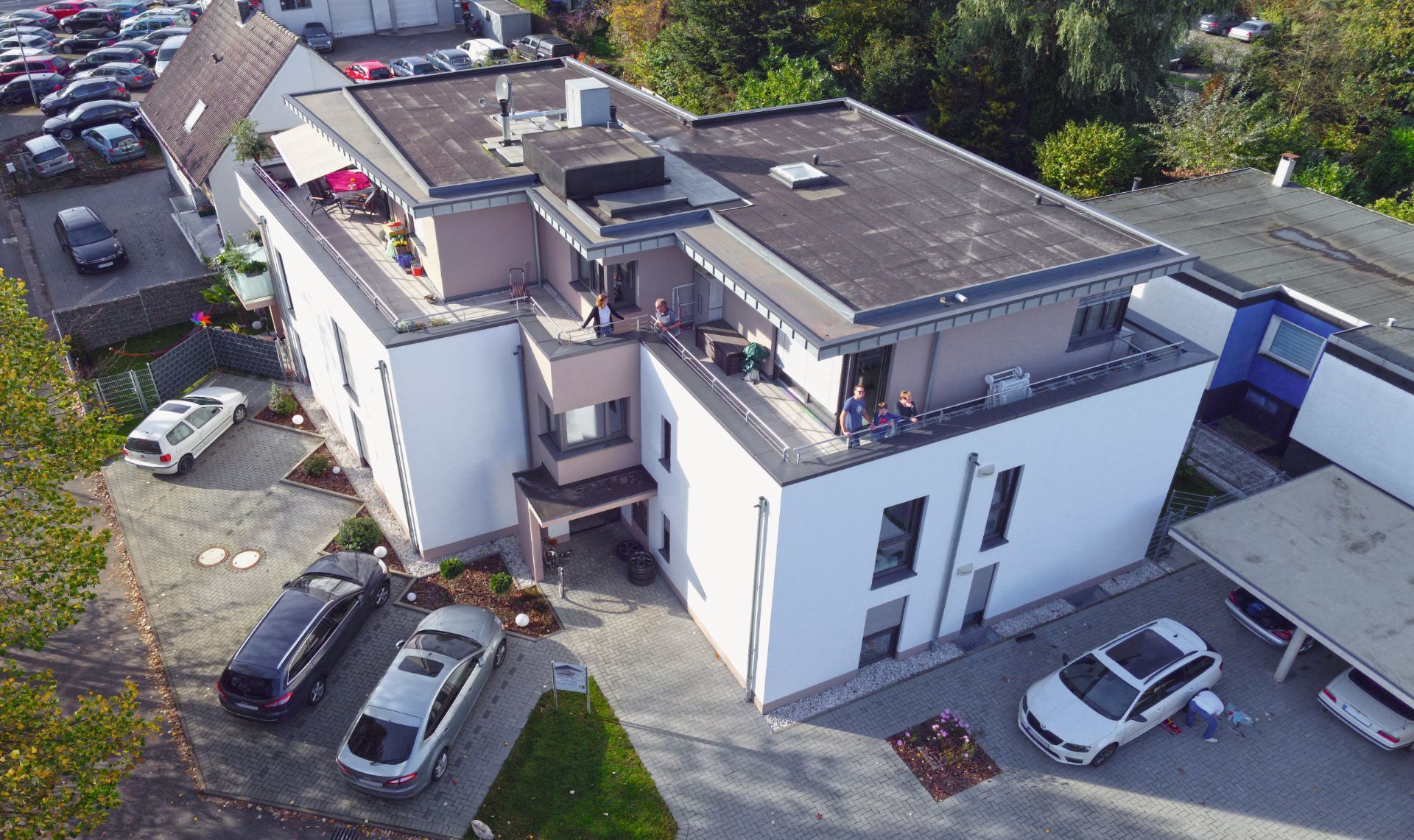 Eine Luftaufnahme eines Gebäudes mit davor geparkten Autos.