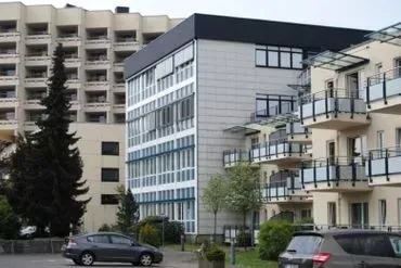 Ein großes Gebäude mit davor geparkten Autos.