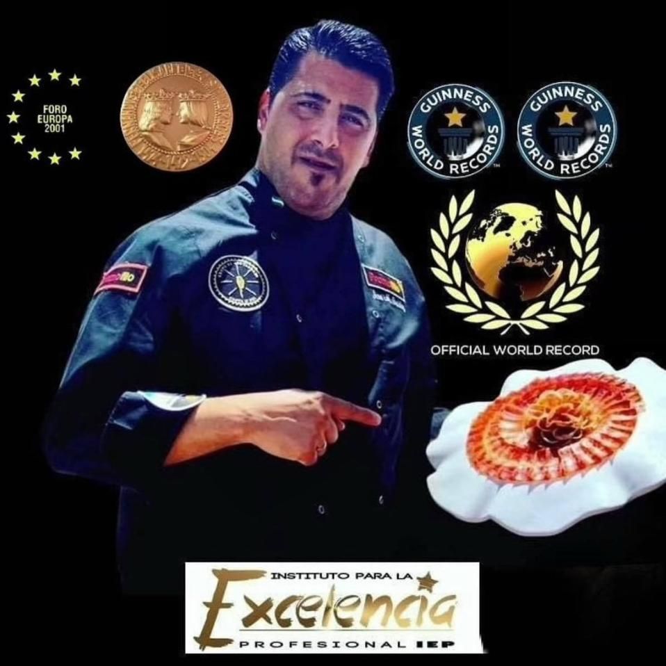 Chef señalando un arreglo decorativo de comida, rodeado de premios y logotipos.
