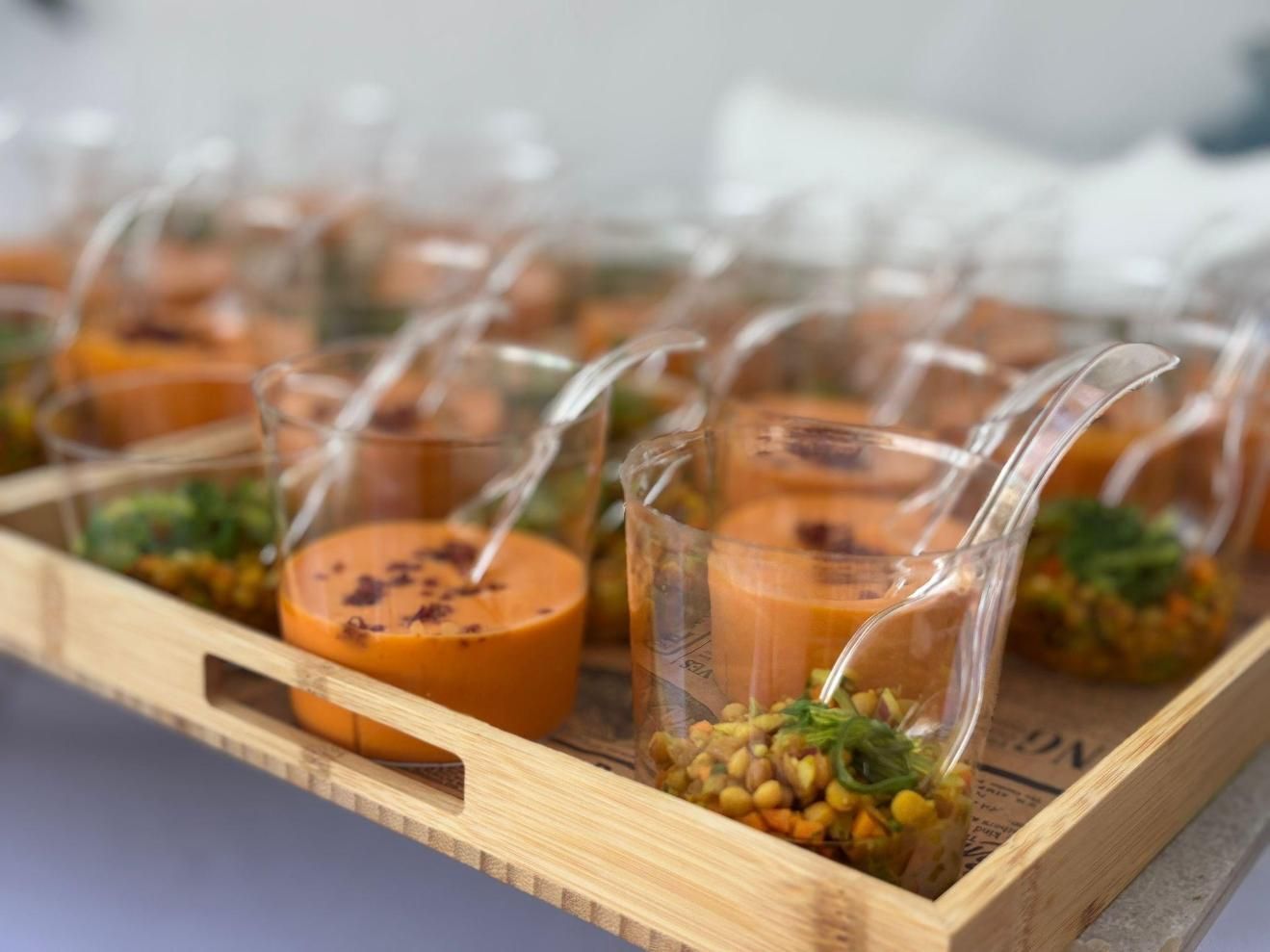 Buffet con numerosas ensaladas en platos blancos, bajo luces brillantes.