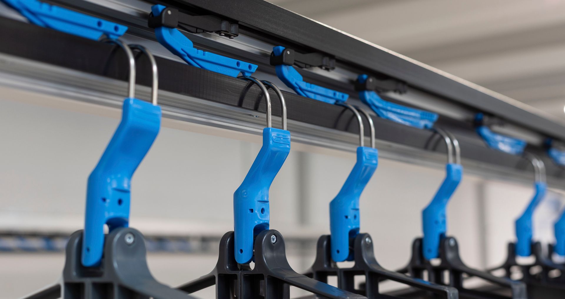 A bunch of blue hangers are hanging on a rack.