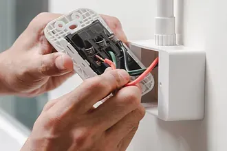 Una persona está instalando un interruptor de luz en una pared.