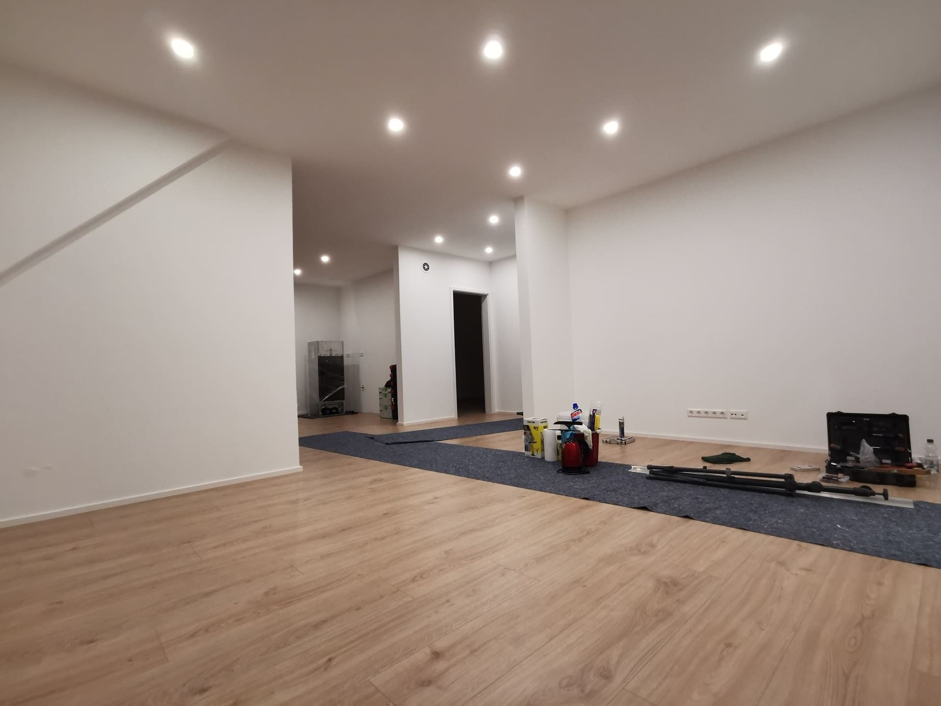 Ein großer leerer Raum mit Holzboden und weißen Wänden.