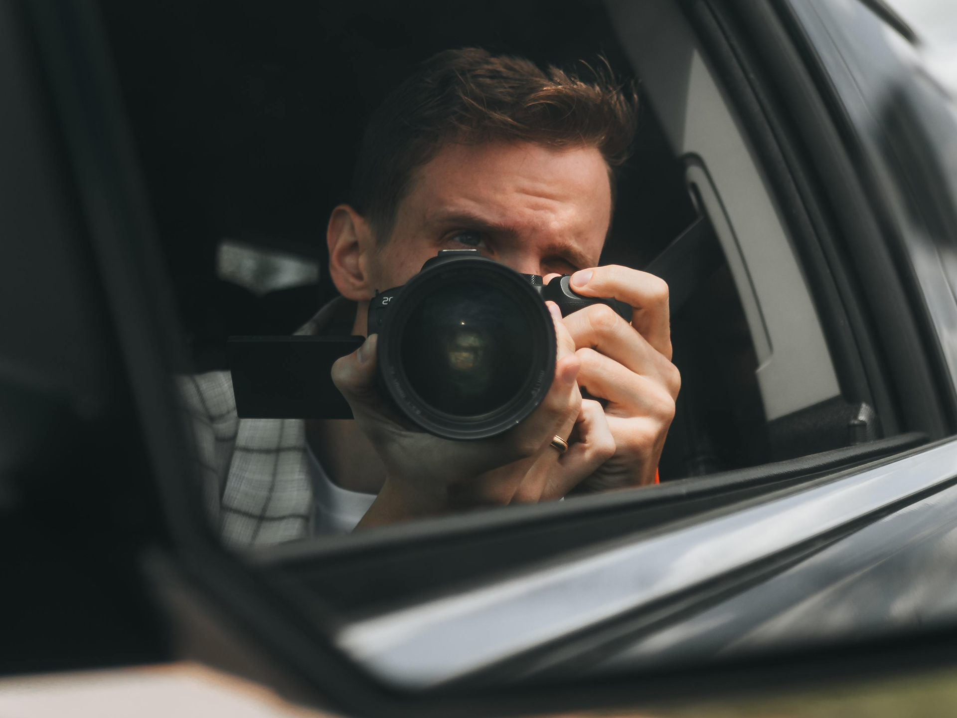 a person sitting on the back seat of the car is clicking a picture