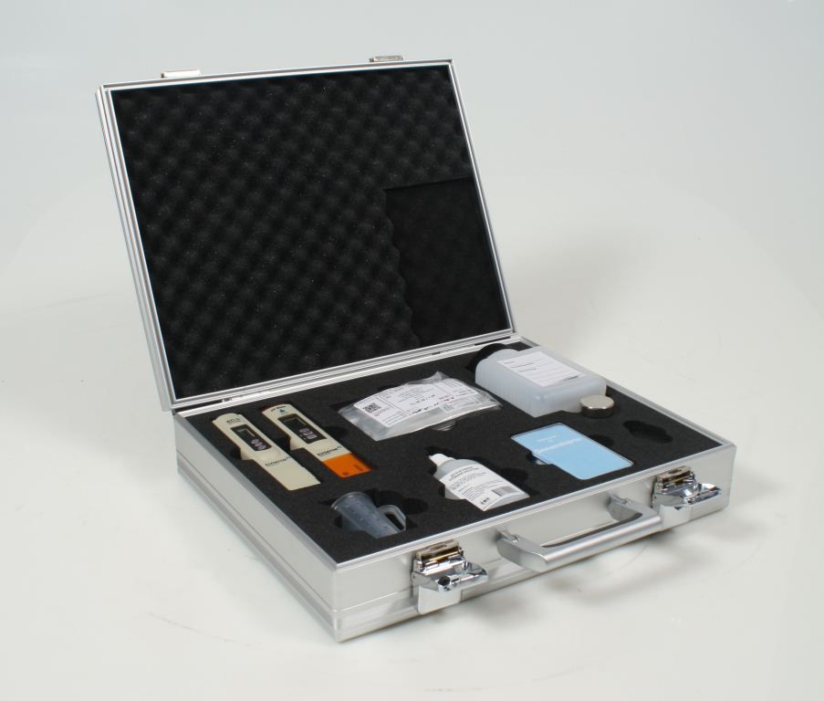 Ein Klempner arbeitet mit einem Schraubenschlüssel und einem Schraubenzieher an einem Heizkessel.