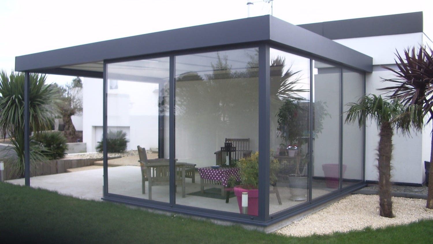 Pergola en alu gris avec deux pans vitrées