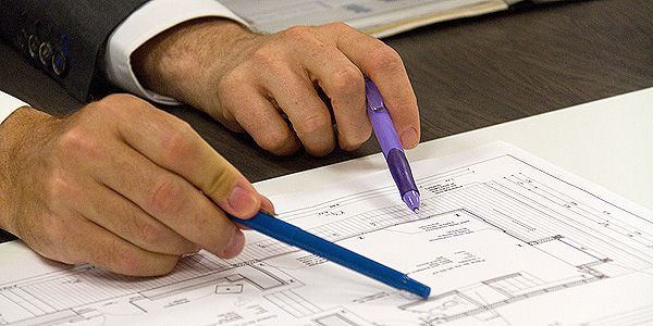 Technicien conseil pointant un crayon sur un plan