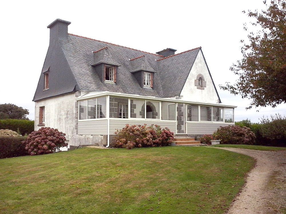 Véranda blanche occupant toute la longueur d'une maison