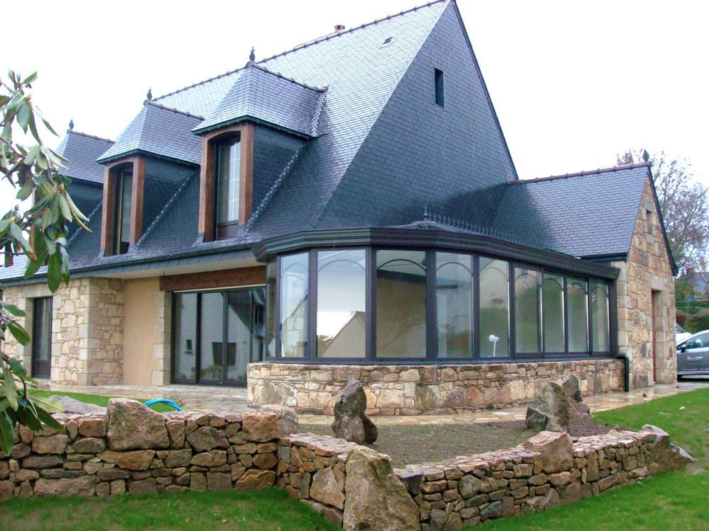 Véranda de style traditionnelle acollée à une belle bâtisse