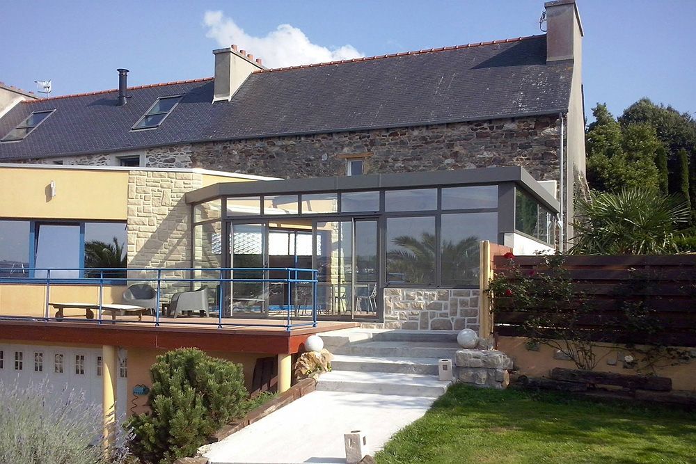 Véranda au toit plat et façades vitrées