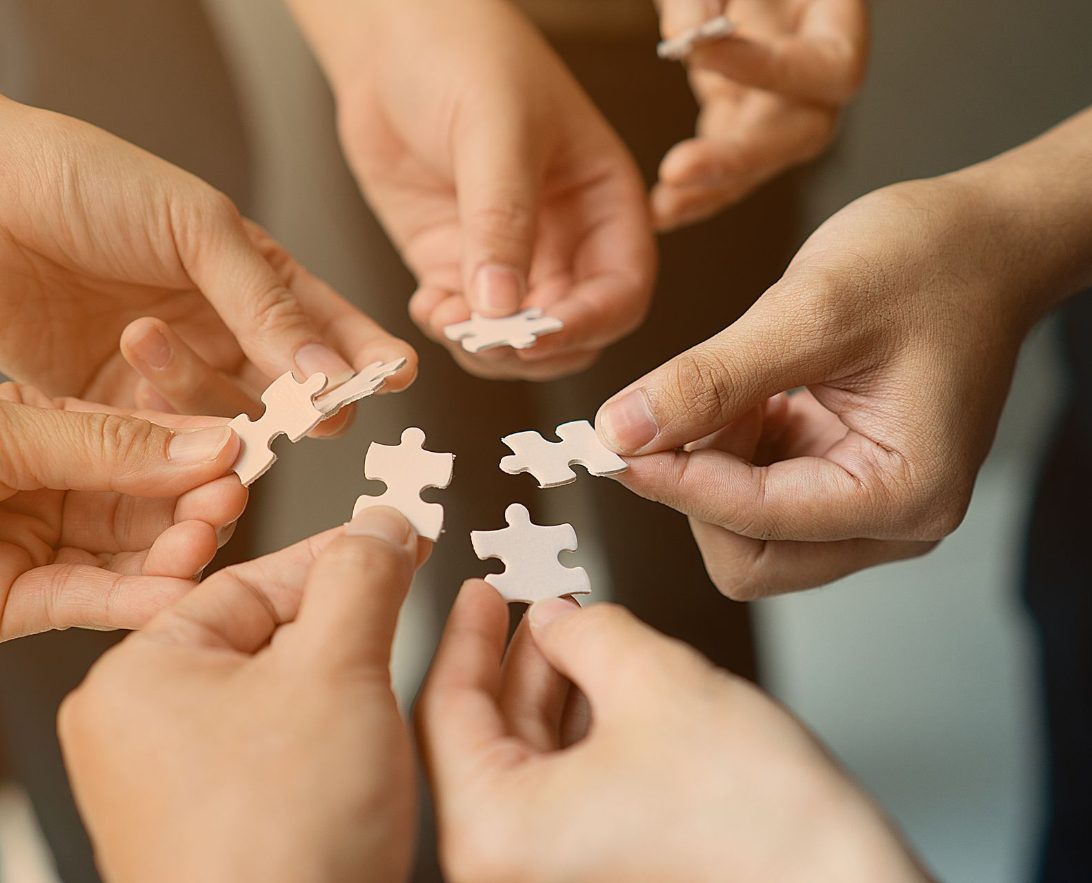 Mains constituant un puzzle