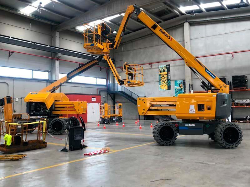 Un gran ascensor amarillo está estacionado en un almacén.