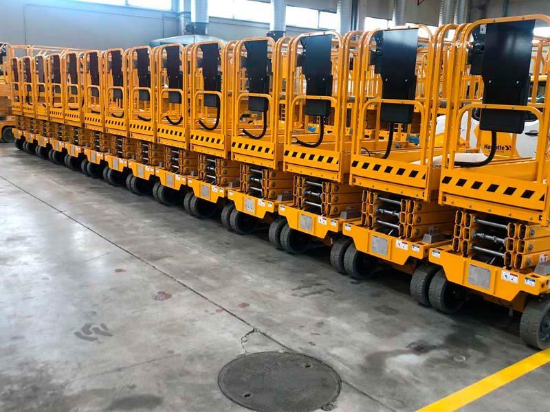 Una fila de vehículos amarillos están alineados en un almacén.