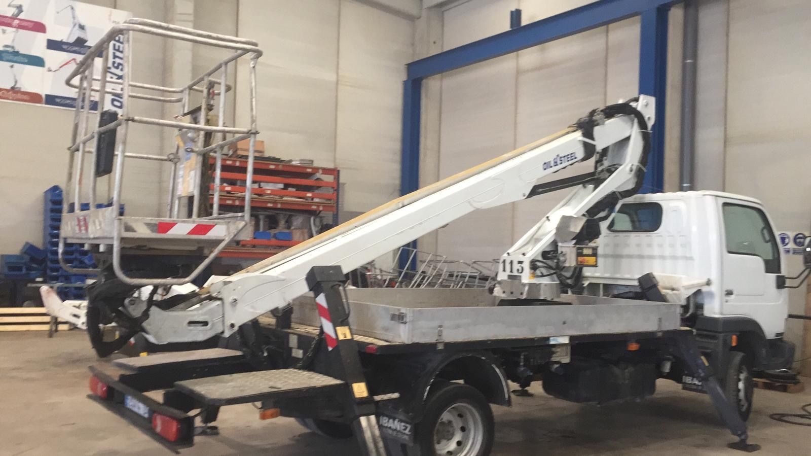 Un camión blanco con una grúa en la parte trasera está estacionado en un almacén.