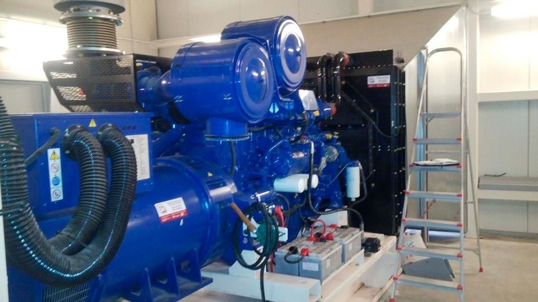 Un generador azul está en una habitación al lado de una escalera.