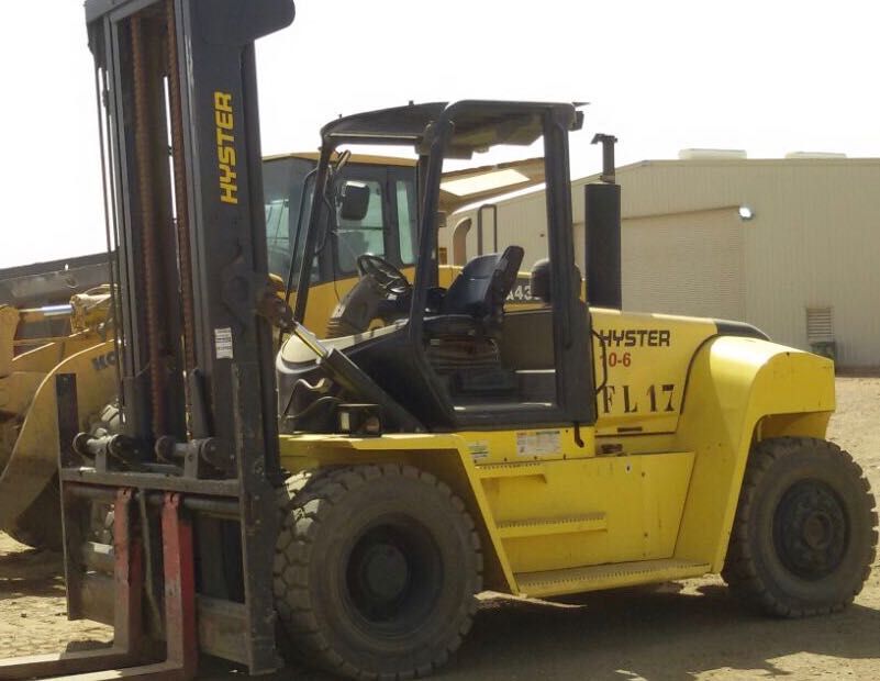 Una carretilla elevadora Hyster amarilla está estacionada en la tierra