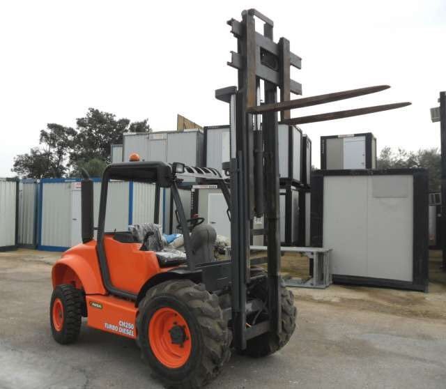 Una carretilla elevadora naranja está estacionada en un estacionamiento