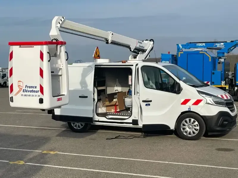 Una camioneta blanca con una grúa encima está estacionada en un estacionamiento.