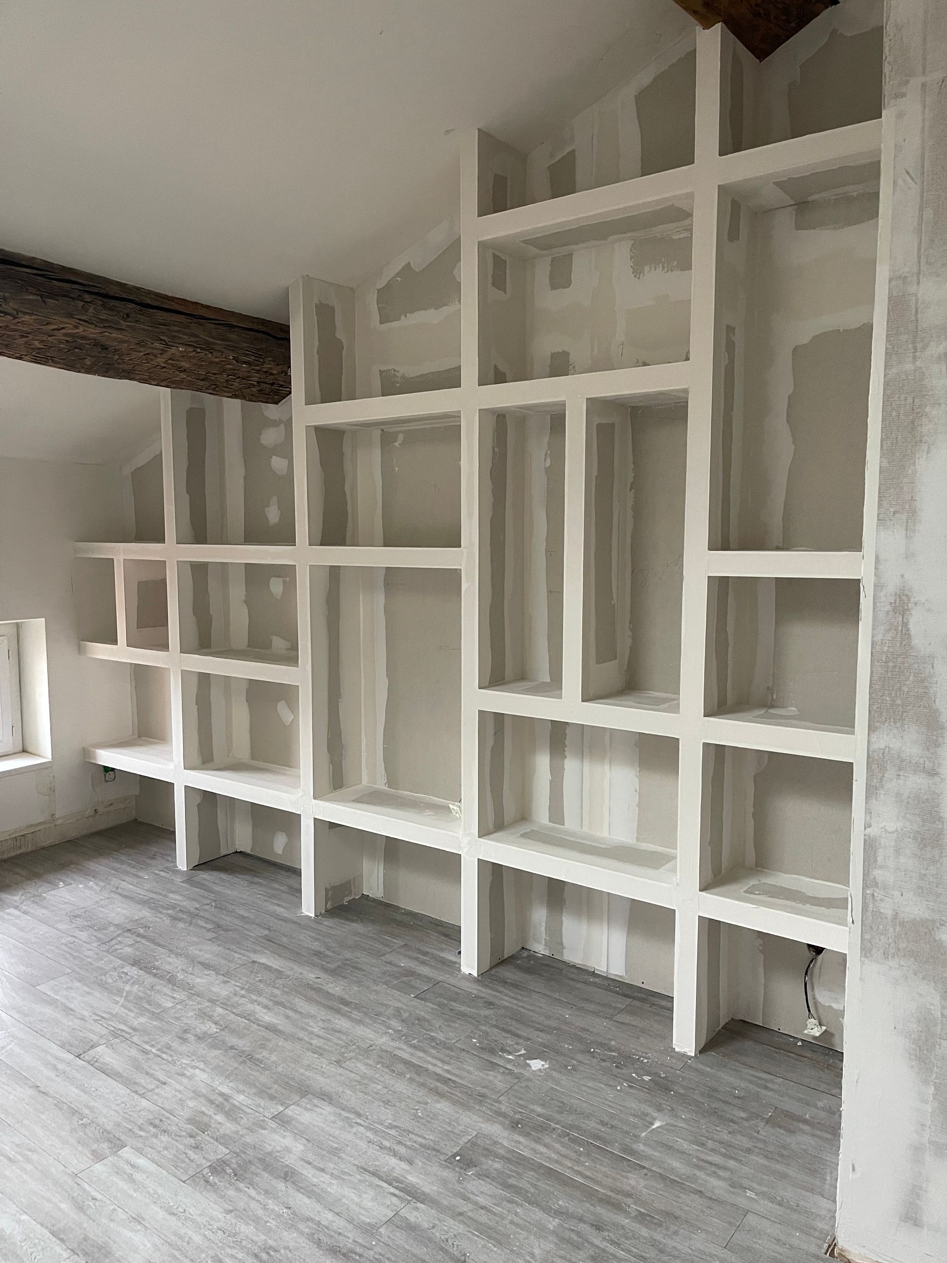 Une femme portant un bonnet rouge tient un appareil photo et prend une photo en extérieur.