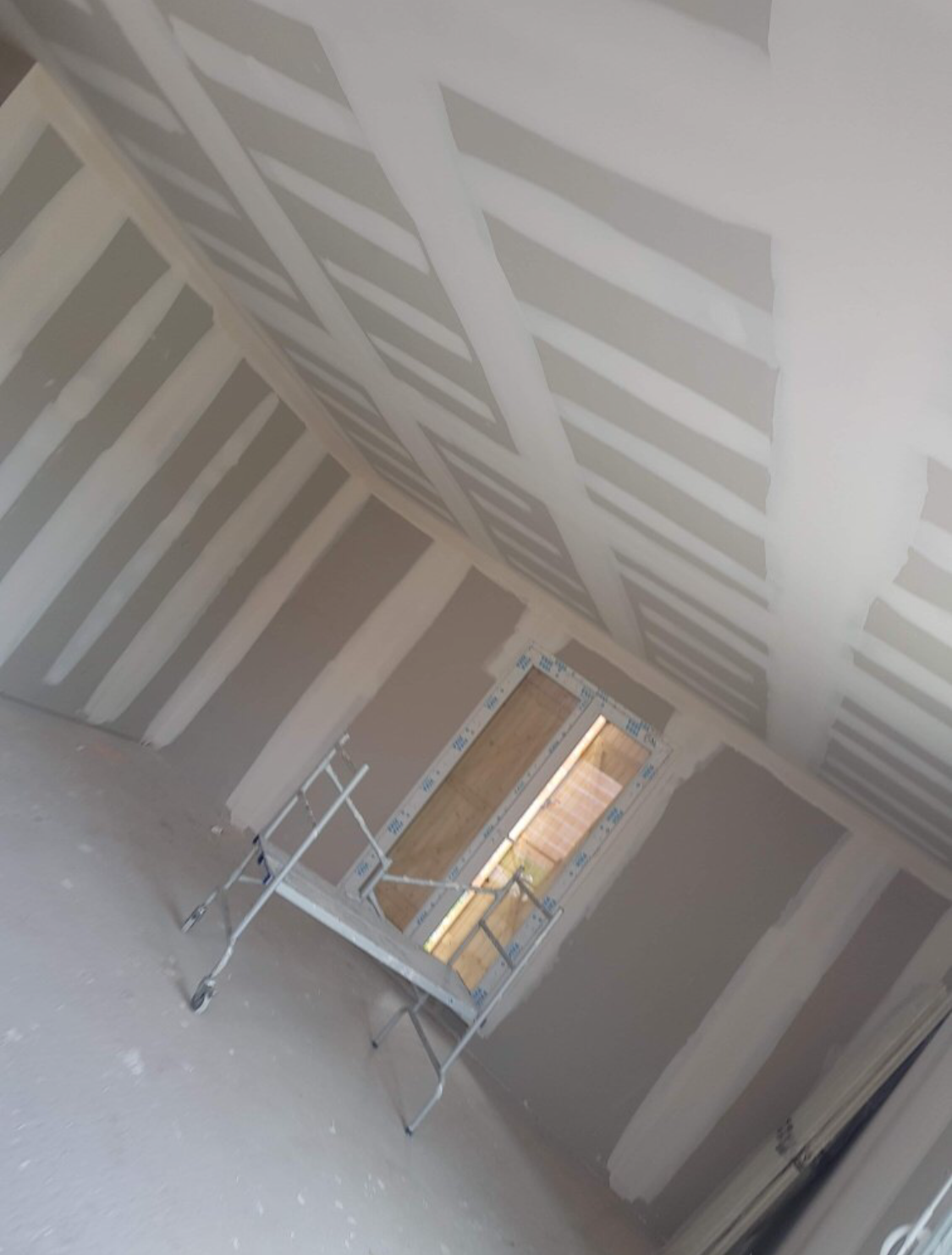 Une femme portant un bonnet rouge tient un appareil photo et prend une photo en extérieur.