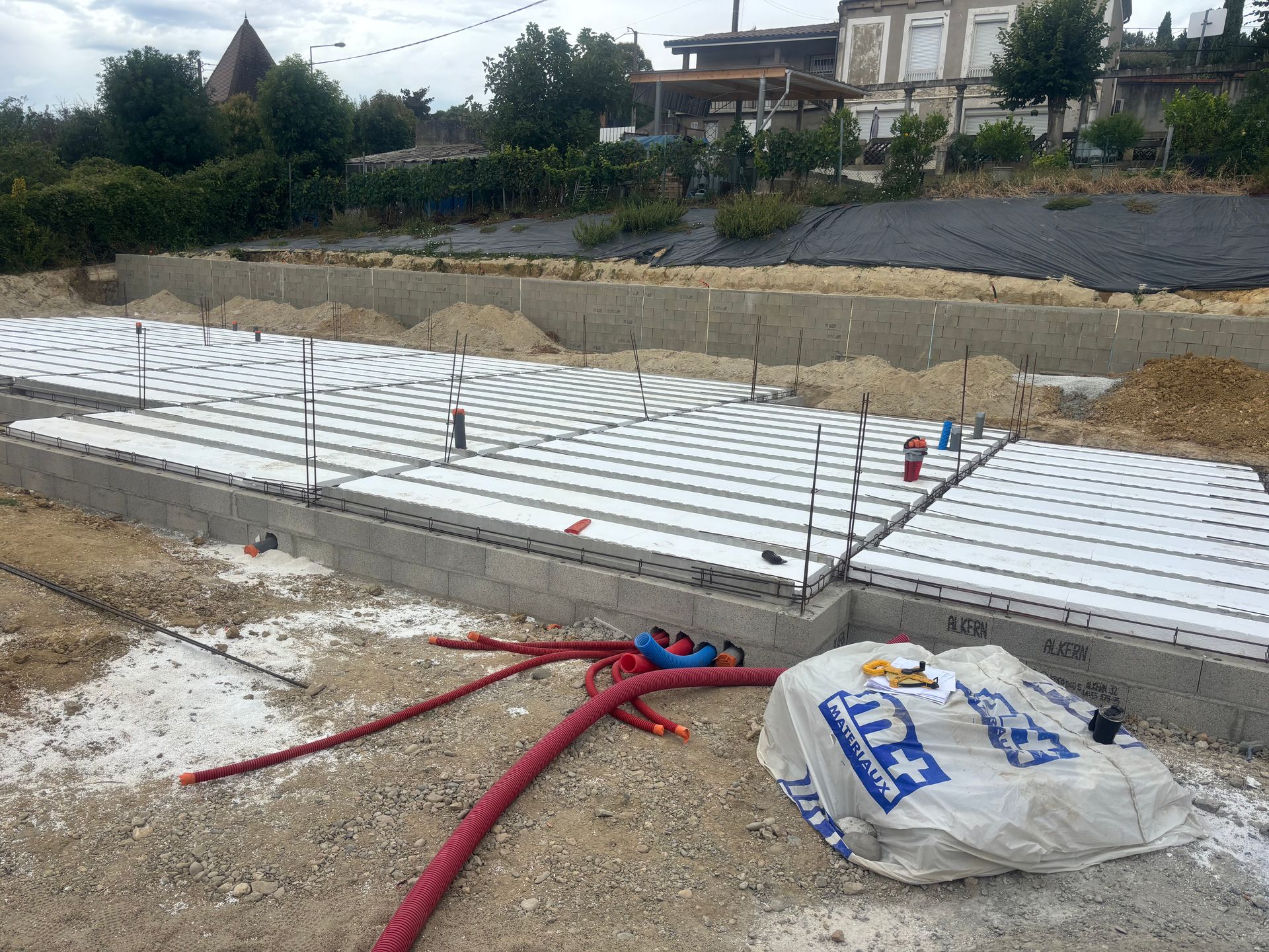 Une femme portant un bonnet rouge tient un appareil photo et prend une photo en extérieur.