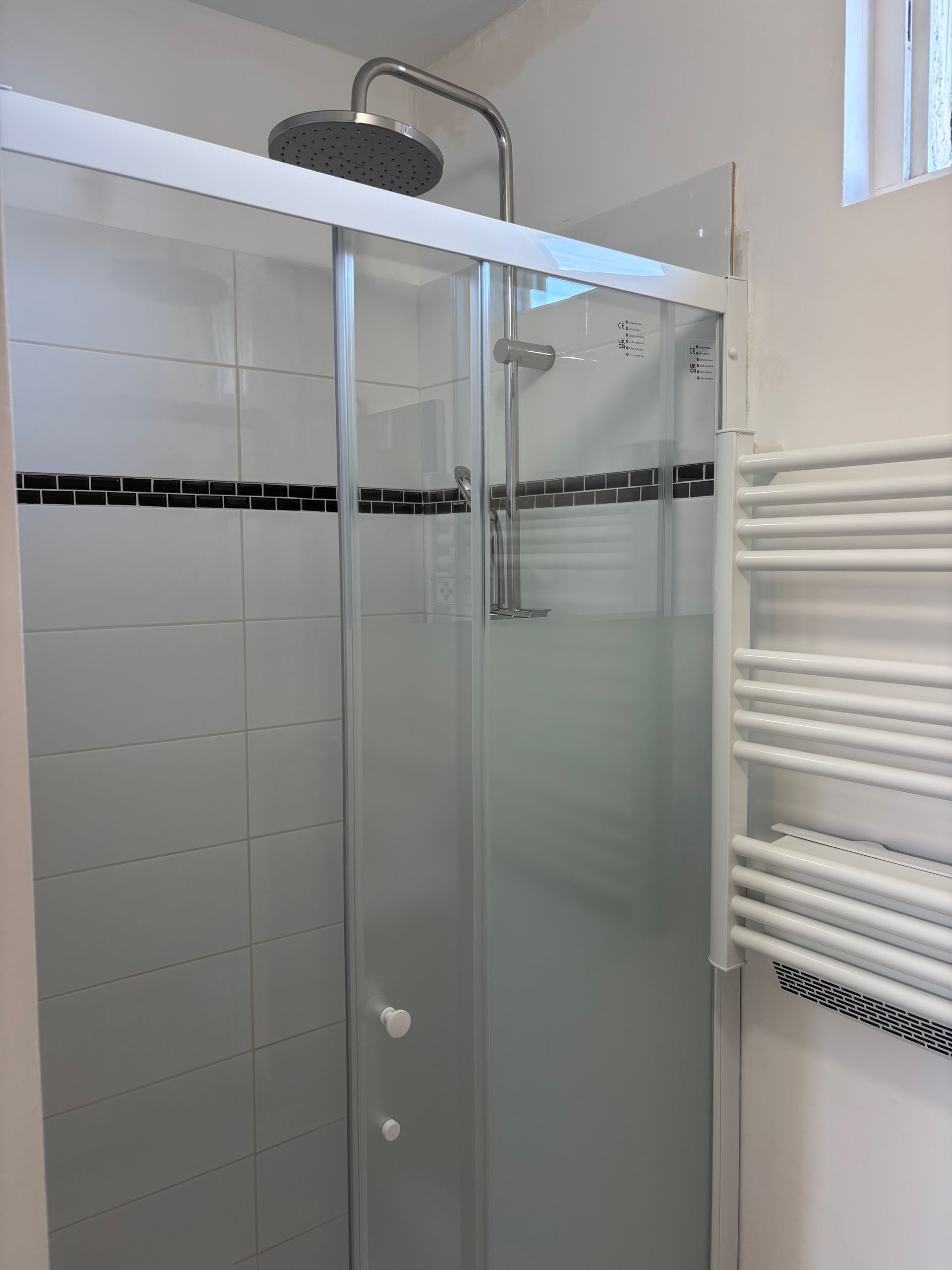 Une femme portant un bonnet rouge tient un appareil photo et prend une photo en extérieur.