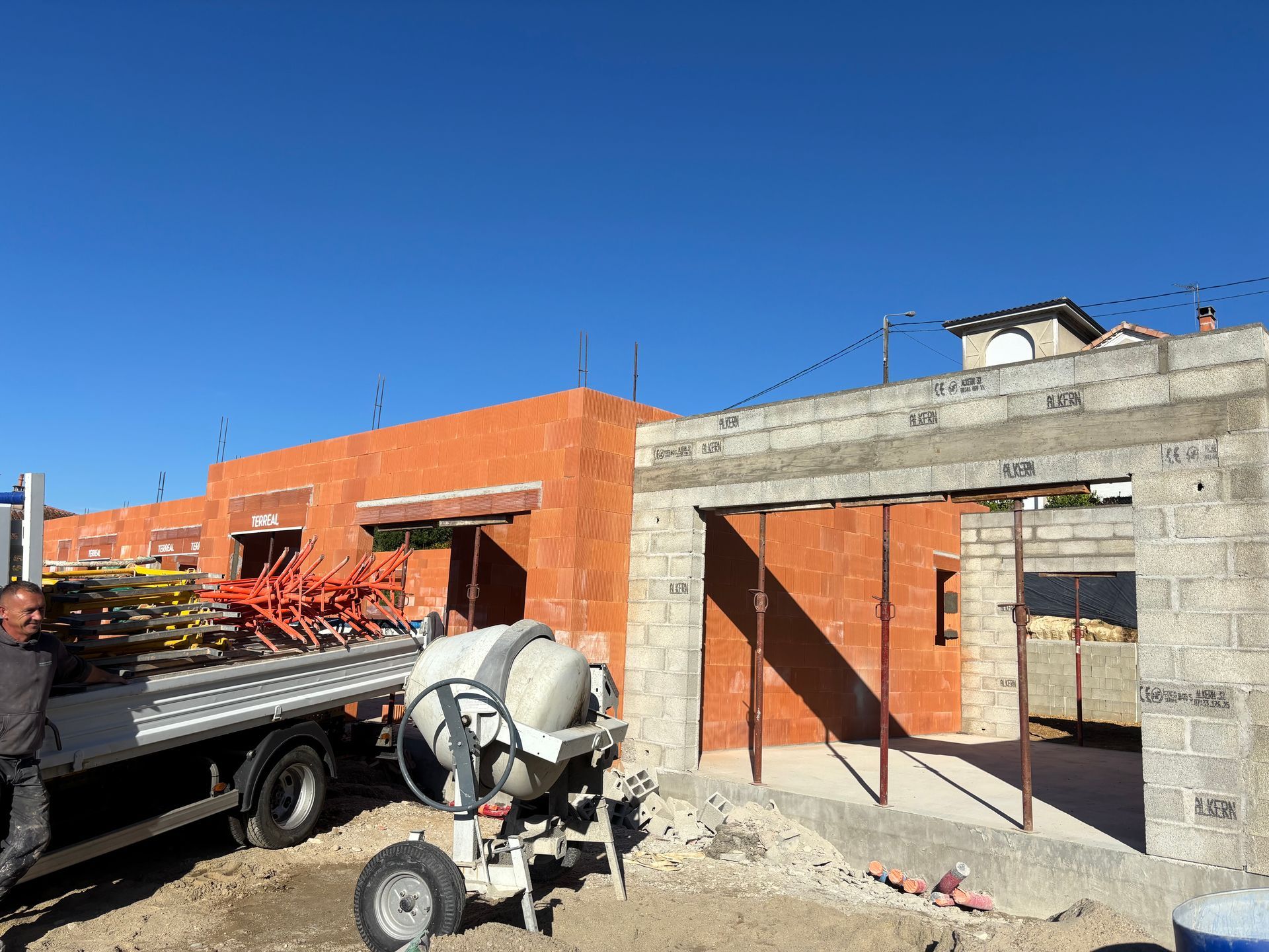 Une femme portant un bonnet rouge tient un appareil photo et prend une photo en extérieur.