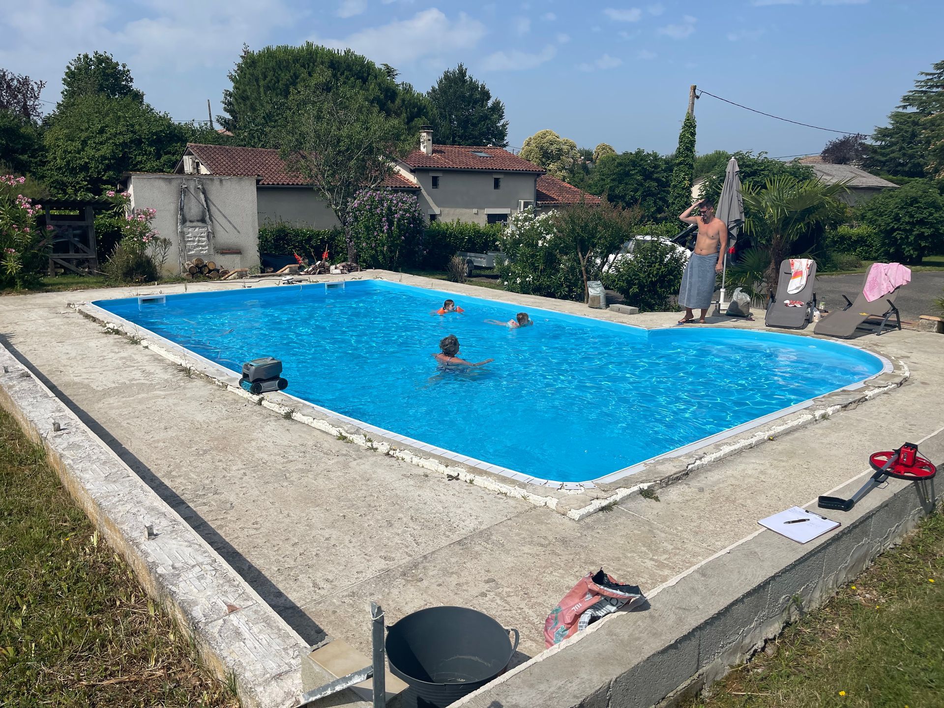Une femme portant un bonnet rouge tient un appareil photo et prend une photo en extérieur.