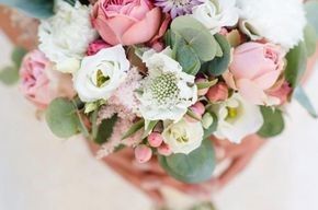 Eine Frau hält einen Blumenstrauß in ihren Händen.