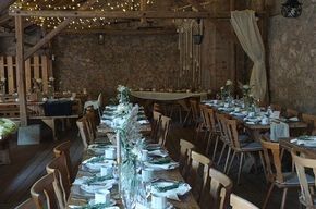 Ein großer Raum mit Tischen und Stühlen für einen Hochzeitsempfang.