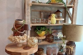 Ein Holzregal mit vielen Vasen und Lampen.