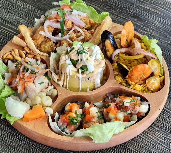 Una bandeja de madera con una variedad de alimentos en ella.