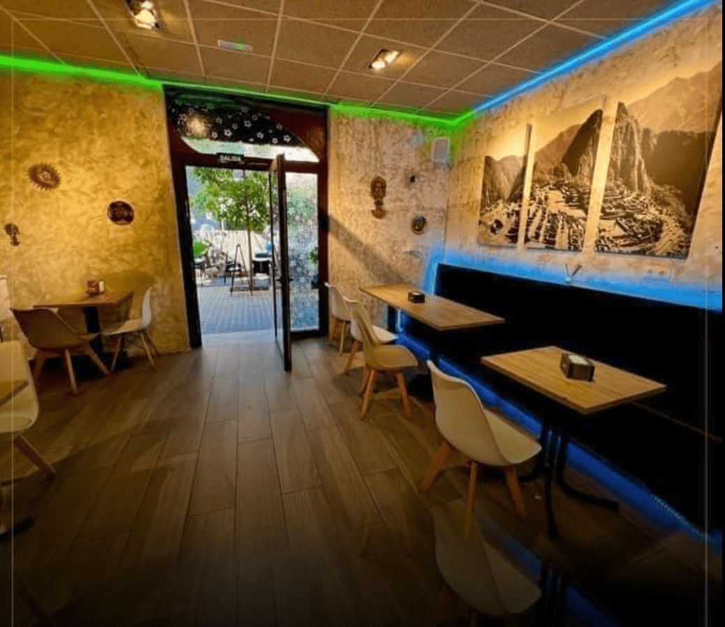 Un restaurante con mesas y sillas y una luz verde en el techo.