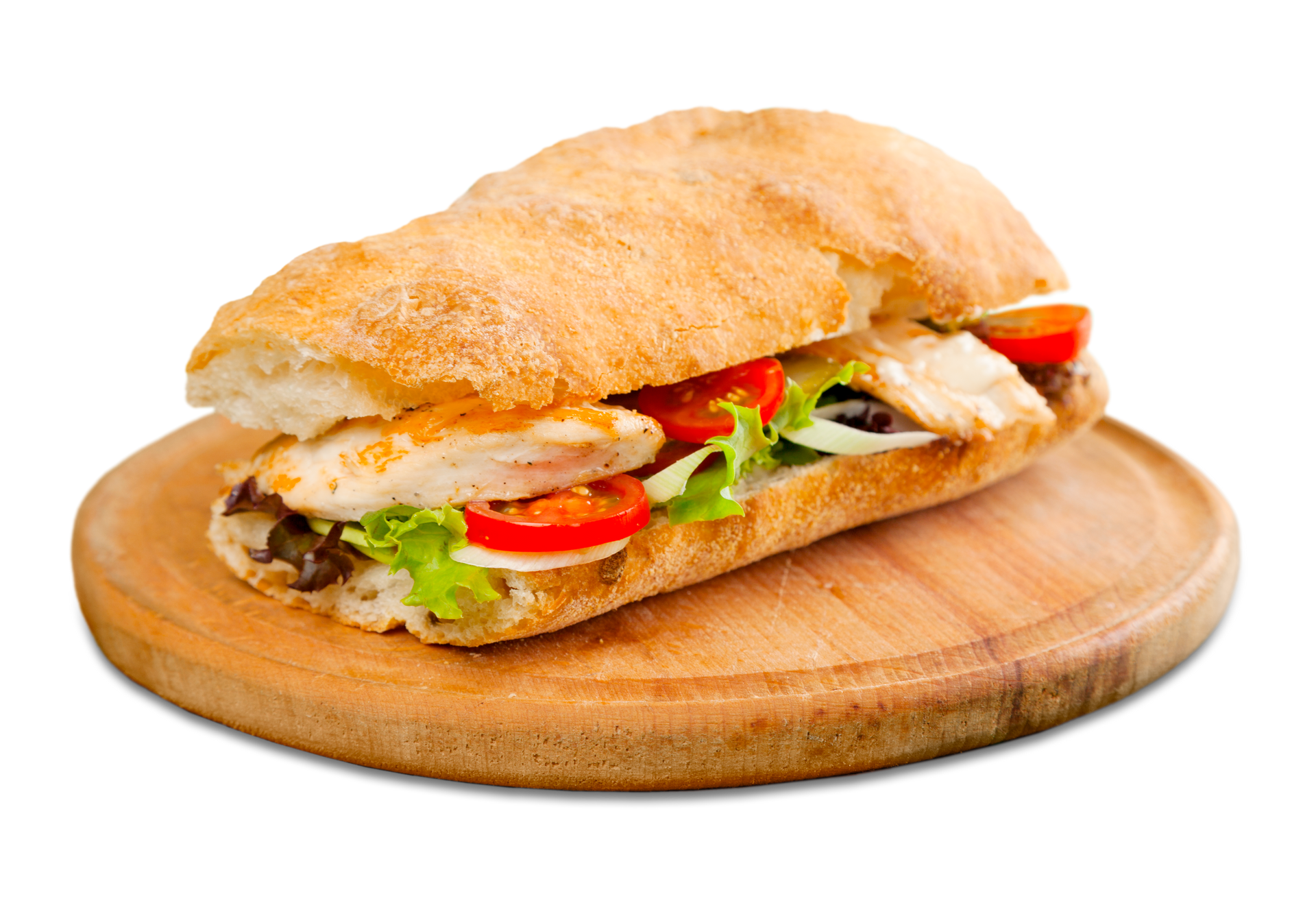 Un sándwich con pollo, lechuga y tomates en una tabla de cortar de madera.