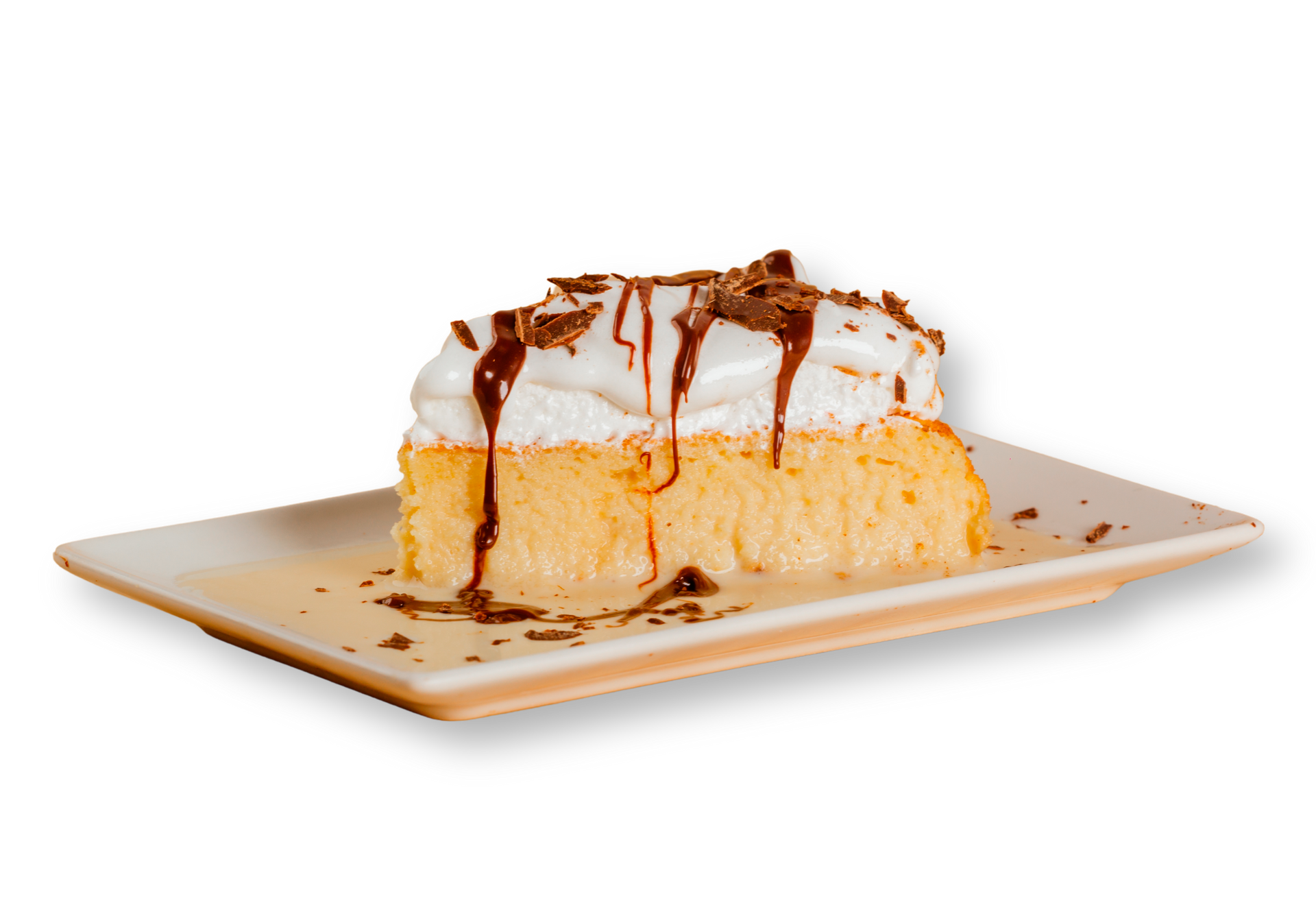 Una rebanada de pastel con crema batida y salsa de chocolate en un plato blanco.