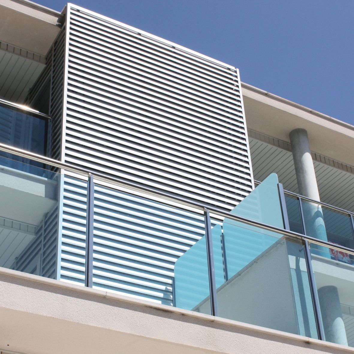 Un edificio con balcón y barandilla azul.