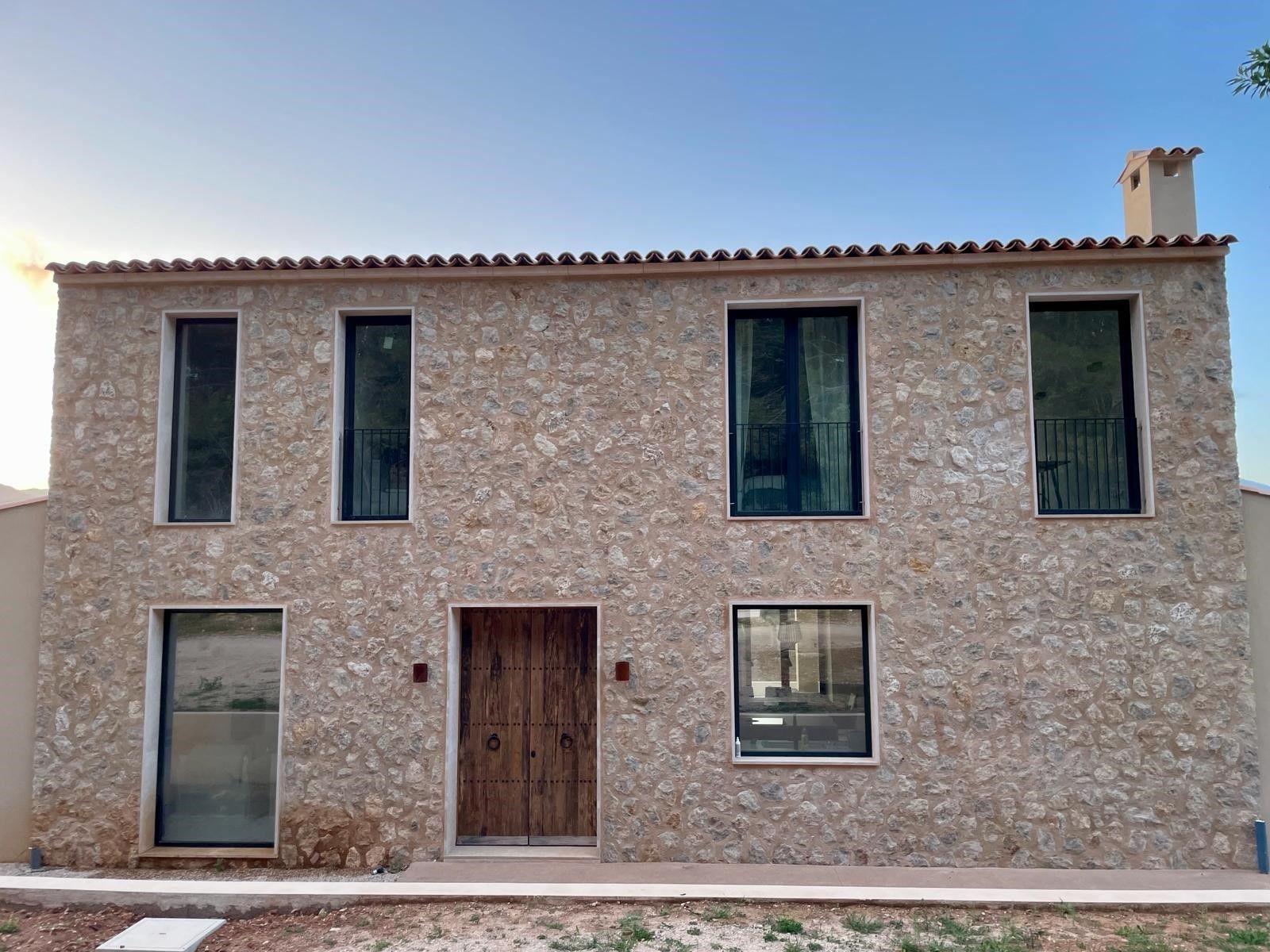 Una gran casa de piedra con puerta y ventanas de madera.