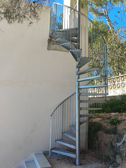 Una escalera de caracol está construida en el costado de un edificio.