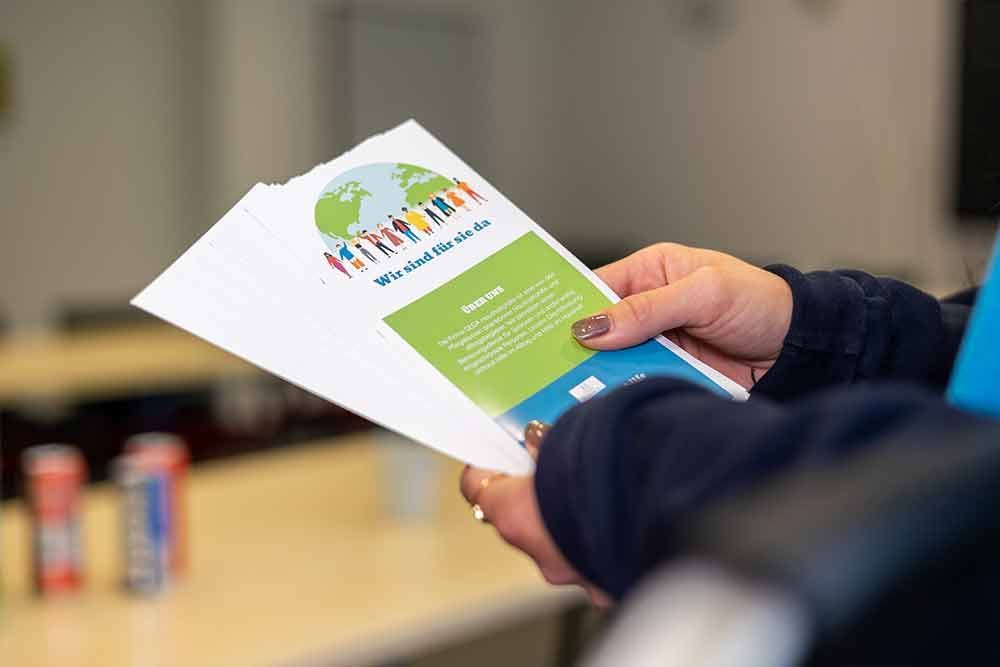 Eine Person hält ein Stück Papier in der Hand.