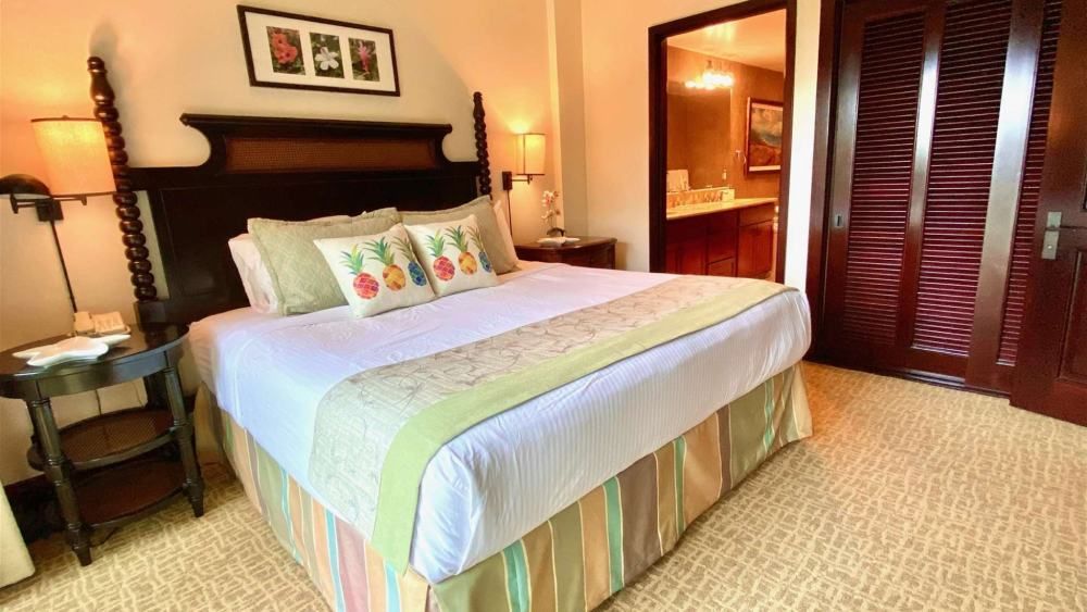 Bedroom with a bed, nightstand, and closed door. Light green, white, and brown color scheme.