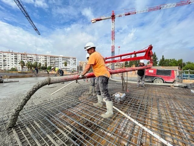 Un hombre está bombeando hormigón en un sitio de construcción.