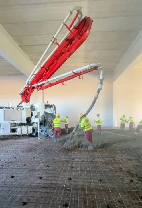 Un grupo de trabajadores de la construcción está trabajando en un piso de concreto.