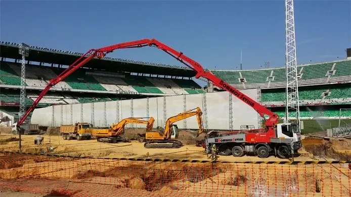 Una obra en construcción con un estadio al fondo