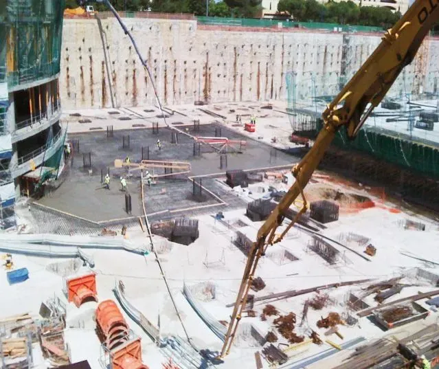 Un gran edificio en construcción con una grúa amarilla en primer plano.