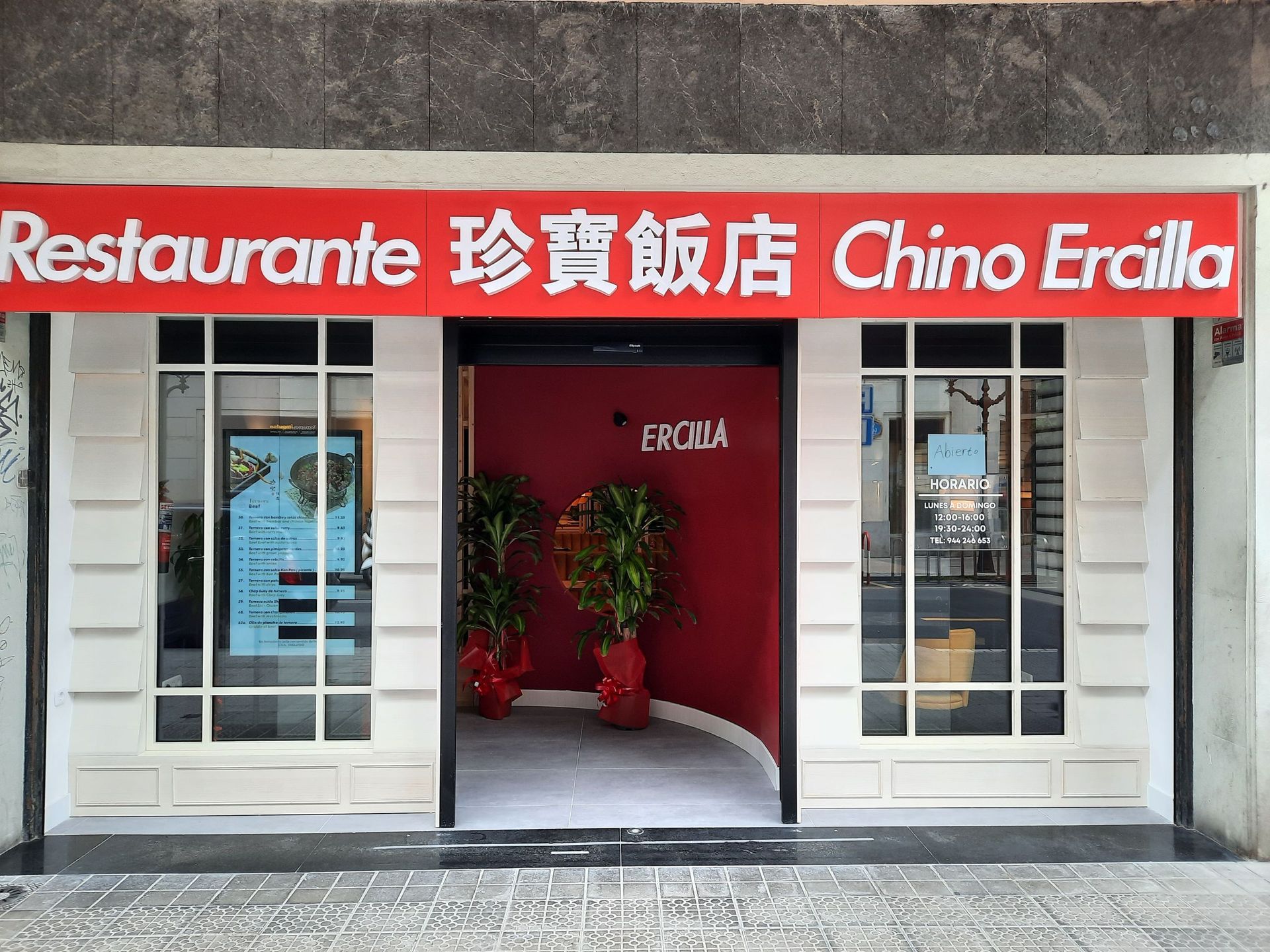El exterior del restaurante Chino Ercilla, con un letrero rojo con texto blanco, ventanas de cristal y una entrada roja.