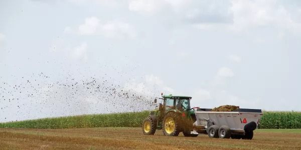 Un tractor está rociando fertilizante en un campo.